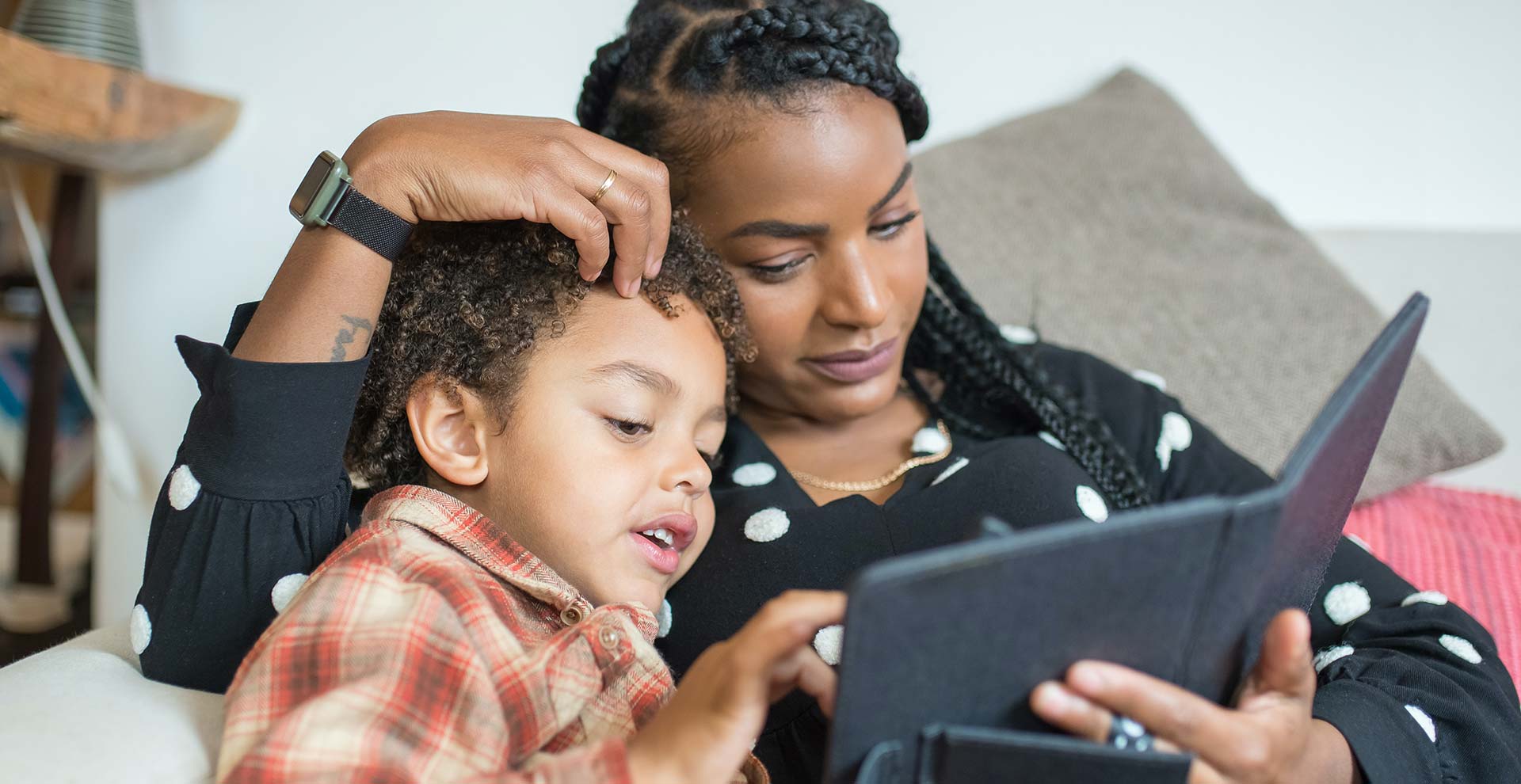 Mutter und Sohn schauen gemeinsam auf ein Tablet