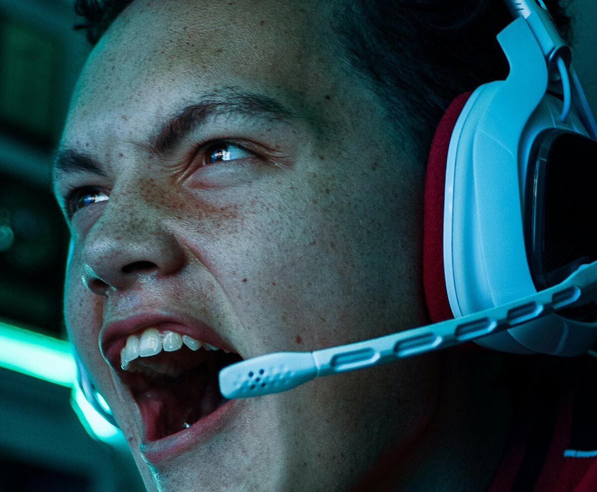 Ein Teenager mit Headset schreit, während er ein Computerspiel spielt